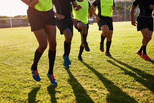 锻炼腿肌肉 一群不知名的运动员在白天打橄榄球前热身 — 图库照片