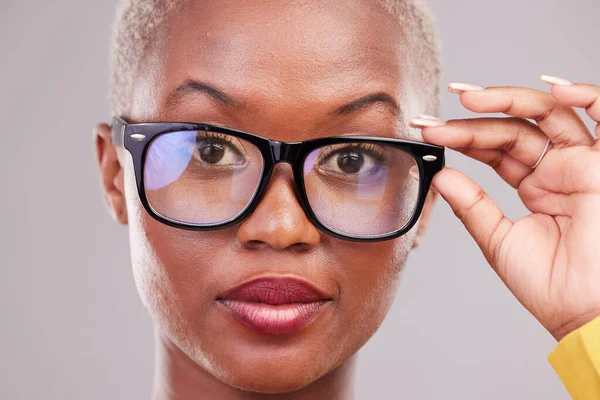 Black woman, face and glasses with vision in portrait, prescription lens and frame isolated on studio background. Female person eyewear, optometry and health insurance with confidence and eye care.
