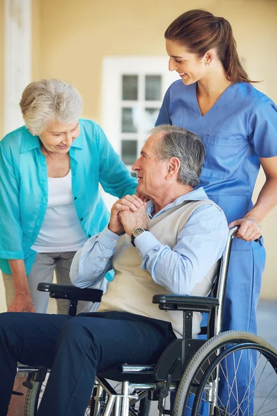 高齢者の妻 介護者または車椅子の老人は 病院のクリニックでサポートのための幸せな患者を助ける 成熟した女性または医療社会福祉士が障害のある高齢者と話す — ストック写真