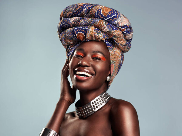 Head scarf, black woman laugh and portrait with African beauty and makeup in a studio. Isolated, grey background and traditional fashion with a female model pride with culture cosmetics and jewelry.