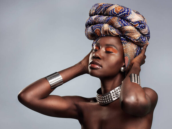 Black woman in traditional turban, fashion and beauty with makeup isolated on studio background. Natural cosmetics, confidence and female model with African head wrap, cosmetic glow and style.