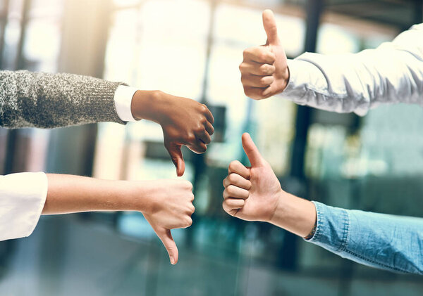 Not everyone will agree with you. a group of unrecognizable businesspeople gesturing thumbs up and down