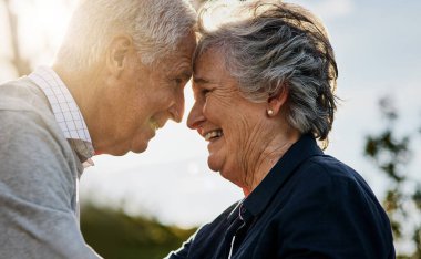 Aşk, doğa ve kıdemli çift ya birlikte ya da dışarıda ya da emeklilikte mutlular. Olgun, erkek ve kadın alnı tatilde gülümser ya da yaşlı vatandaşlar parkta flört eder ve kucaklaşırlar.