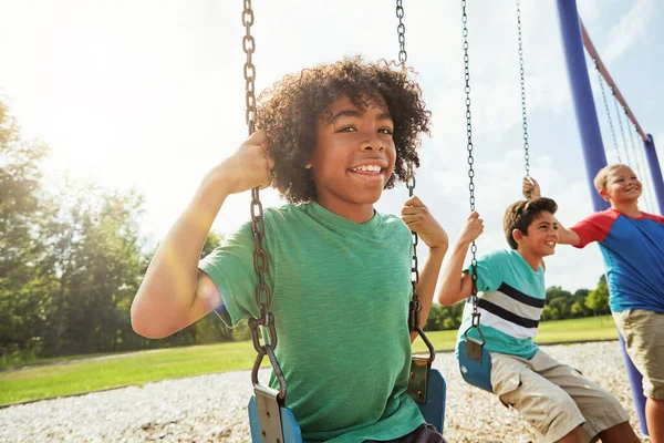 野外劇の日を作る 友達と公園でスイングで遊んでいる若い男の子の肖像画 — ストック写真