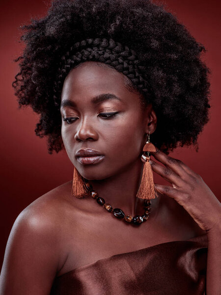 Beauty, natural skin and black woman in studio with glow on gradient, maroon or red background. Face, makeup and African lady model with culture, pride or cosmetic, isolated or style and aesthetic.