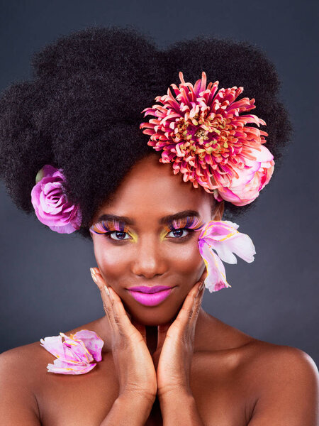 Makeup, flowers and art with portrait of black woman in studio for beauty, creative or spring. Natural, cosmetics and floral with model isolated on gray background for color, self love or confidence.