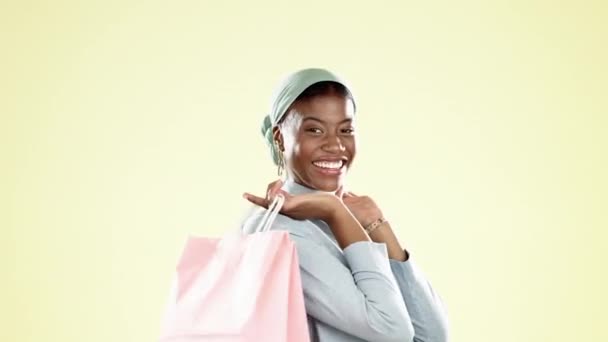 与黑人妇女一起购物袋和零售 并为设计师 产品和消费者眨眼 在黄色背景工作室与穆斯林女孩客户进行精品店 狂欢和时尚的交易 提供和销售 — 图库视频影像