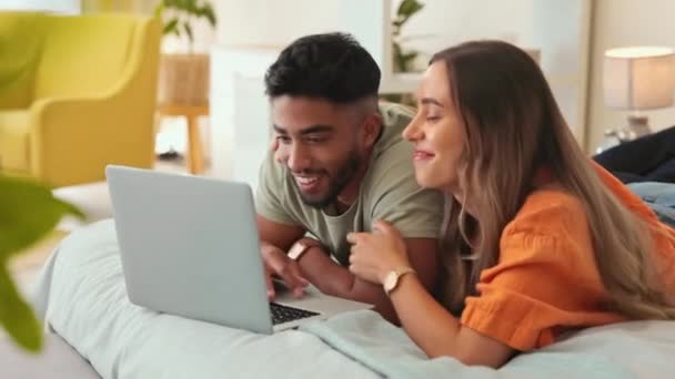 ベッドルームのベッドの上に寝そべっているラップトップ ビデオ カップルは 絆を保ちながらリラックスします 週末に家の中で休んでいる男と女とコンピュータ インターネットや映画 — ストック動画