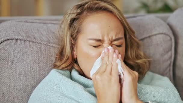 アレルギー Covidウイルスおよび副鼻腔炎の風邪のために家で鼻を吹く病気のアジアの女性 医療問題 医療疾患 発熱から回復するソファの上の女性の顔のくしゃみ インフルエンザやアレルギー — ストック動画