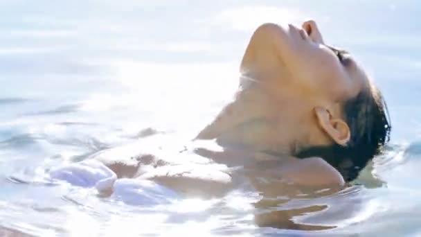 여자가 화장을 수영장에서 수영하는 자신감을 느낍니다 여름에 야외에서 떠다니며 편안하게 — 비디오