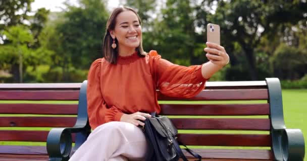 微笑和亚洲女人在公园的长椅上为社交媒体拍照 相貌照片和一个人坐在户外拍照 以获得快乐的回忆 舌头伸出或滑稽的脸 — 图库视频影像