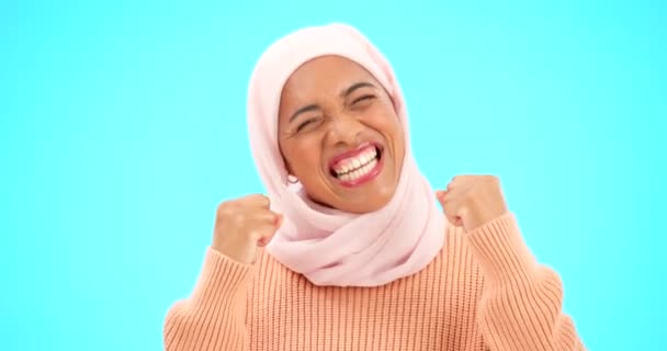 ムスリム女性 幸せなお祝いや販売や広告スタジオのプロモーションに興奮しています イスラム女性拳 手とヒジャーブは青の背景にボーナス勝利 競争目標や宝くじを祝うために — ストック動画