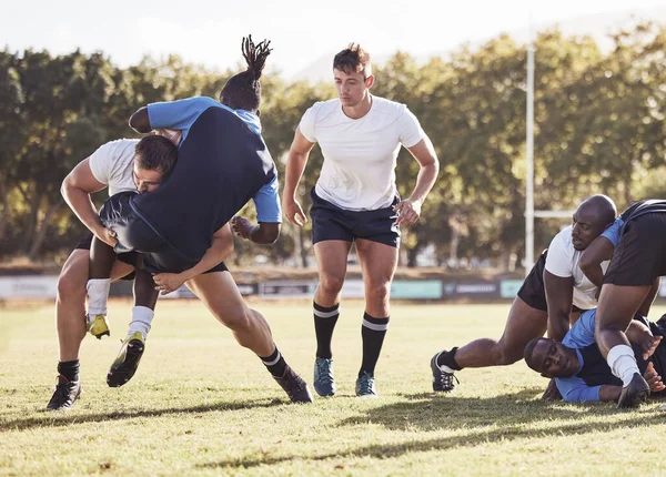 stock image Rugby, sports and men tackle for ball on field for match, practice and game in tournament or competition. Fitness, teamwork and players playing on grass for exercise, training and performance to win.