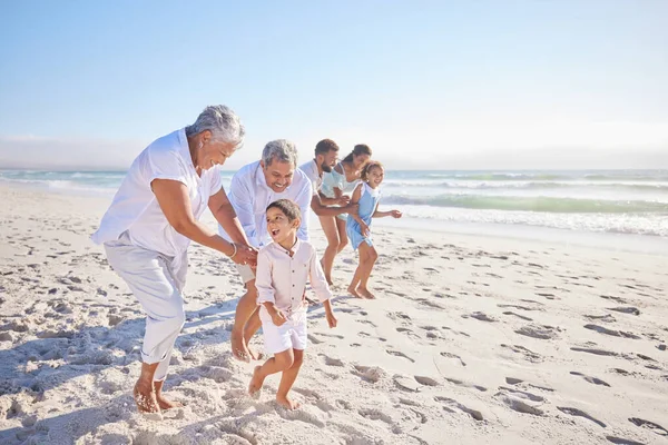 Vacation, travel and big family running on the beach for playing, bonding and spending quality time. Happy, excited and children having fun with their grandparents and parents by the ocean on holiday.