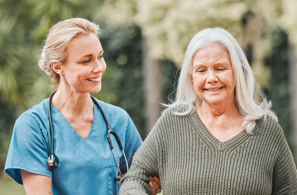 Support, smile and nurse walking elderly woman in a garden to relax, wellness and morning exercise in the lawn. Trust, nursing home and caregiver help senior person smile and happy for outdoor walk.