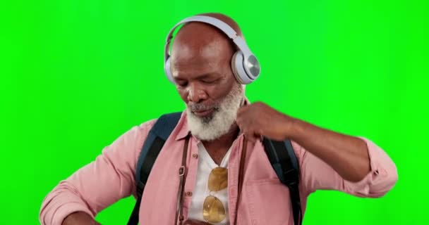 屈託のないコンテンツながら 緑の画面上の黒人男性 ダンスや音楽のヘッドフォン アフリカのシニア男性ダンススタジオの背景にモックアップスペースとオーディオ サウンド ラジオを聞くバックパック — ストック動画