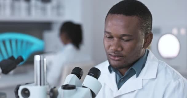 Μαύρος Επιστήμονας Εργαστηριακό Μικροσκόπιο Και Πόνος Στον Ώμο Ενός Εργάτη — Αρχείο Βίντεο