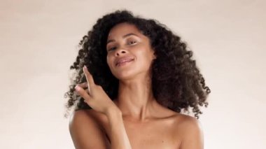 Güzellik, cilt bakımı ve kozmetik, tatmin ve kendini beğenme için stüdyoda siyahi bir kadının yüzüne dokunmak. Kozmetik ürünleri, kendine güvenen ve kahverengi arka planda temiz, doğal ve spa modelleri ile parıldayan.