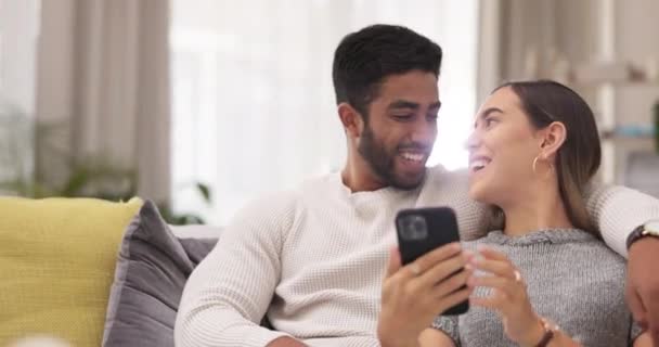 自宅のソファの上で電話 幸せなカップルは 品質の時間とリラックスしたリビングルームで 異人種間の関係 ソーシャルメディアのためのスマートフォン上の愛と男と女 インターネットとウェブサイト — ストック動画