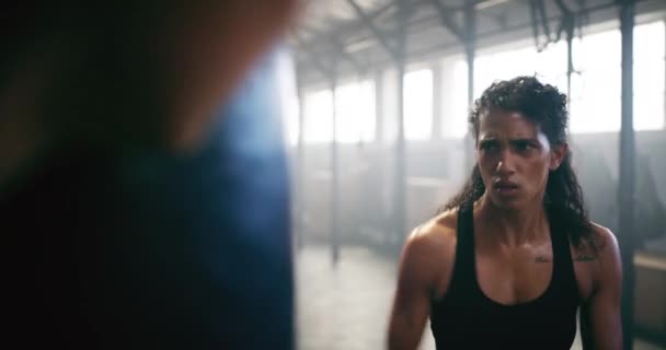 ボクシング 武道のためのジムで女性と発汗とパンチングバッグ ワークアウトと強い トレーニング パフォーマンスのためのMmaフィットネスセンターで女性ボクサーとフォーカス 健康と心臓 — ストック動画