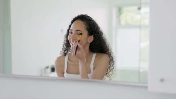 快乐的女人 脸上和眼睛化妆美容化妆品 护肤或梳妆打扮在家里的浴室镜子里 女性刷眼罩或使用产品进行自恋或早间面部治疗 — 图库视频影像