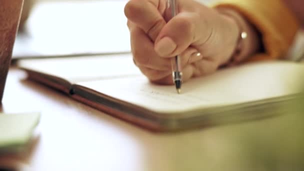 在家里的笔记本上写着手笔 按照学习时间表和学习计划工作 笔记和书桌 有一名女学生和一名从事杂志学习的有创意的作家 — 图库视频影像