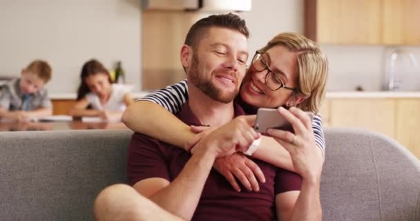 拥抱和放松与一对夫妇在沙发上在客厅里 他们的家在一起粘合 与男人和女人在家里的手机上浏览社交媒体的移动 快乐或爱情 — 图库视频影像