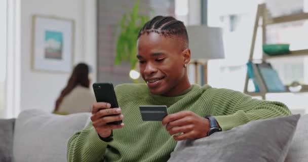 信用卡 电话投资和黑人男人在客厅的沙发上的电子商务应用程序 付款和年轻人在沙发上做金融 网上零售和数字购物 — 图库视频影像