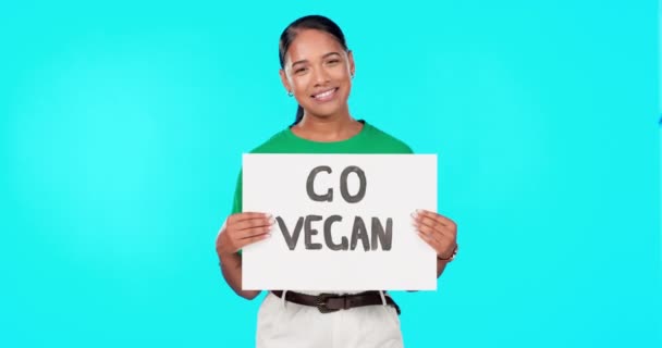 若い女性 健康のための顔に笑顔で青の背景でビーガンポスターや抗議に行く 食事や生態系 ボランティア 活動家 動物の優しさ 変更や食品の革新のための紙のボード上の署名 — ストック動画