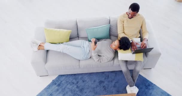 与社交媒体一起在沙发上 与笔记本电脑 电话和放松的情侣 顶视图和客厅 黑人男子 妇女和在休息室用计算机从家里连接 交流或工作的技术 — 图库视频影像