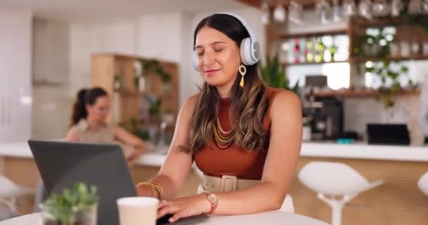 リモートオンラインで作業しながら フリーランスの女性がオーディオストリーミングとノートパソコン 音楽やコーヒーショップ カフェでラジオを聞いている女性起業家とコンピュータ フリーランス ヘッドフォン — ストック動画