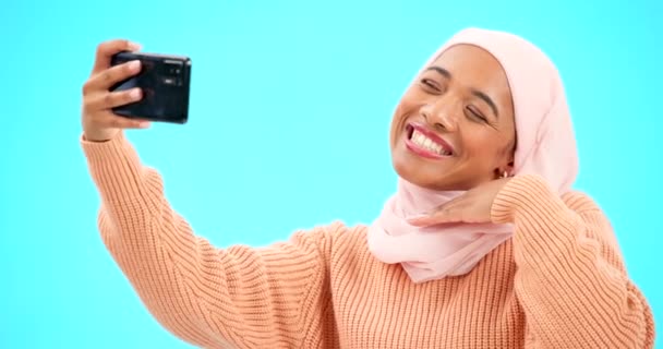 穆斯林女性的自拍被蓝色背景隔离在网上社交媒体的亲吻 微笑和感情用事 图片中快乐的伊斯兰基因Z或Hijab人的脸或工作室中的影响者生活方式 — 图库视频影像