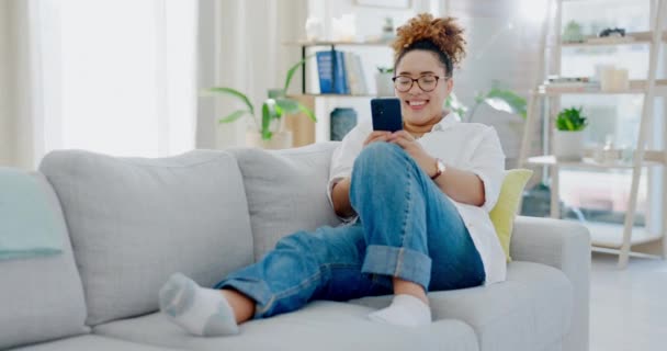 ソファの上で女性 電話やテキストメッセージは 家の中でソーシャルメディア ミームや通信インターネットでリラックスする Gen Girl スマートフォンやアプリのUx 技術や家のリビングルームで笑顔でビデオを見るとチャット — ストック動画