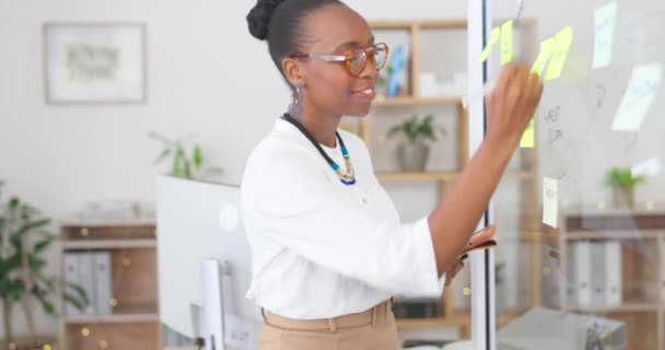 オフィスのガラス板上の計画 ビジネススケジュール または粘着性のあるノートのための幸せな黒人女性 タブレットや執筆 アフリカ系アメリカ人女性の職場でのプロジェクトのブレーンストーミングのアイデア タスクまたは戦略 — ストック動画