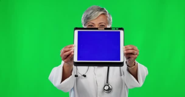 スタジオの背景を追跡するマーカーと緑の画面上の女性 医師やタブレット モックアップ上のオンライン電話の健康のためのタッチスクリーンディスプレイを示す幸せなシニア女性医療専門家の肖像画 — ストック動画
