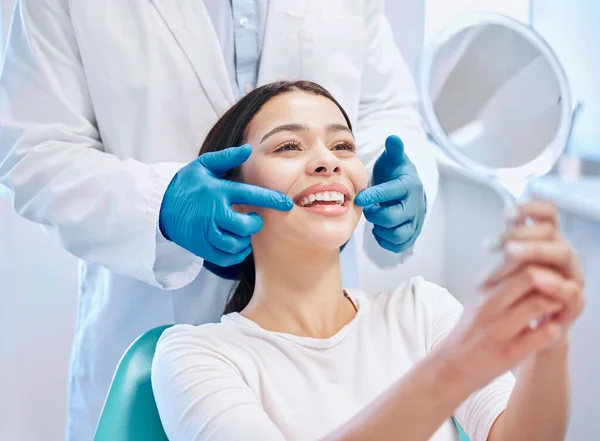 stock image Dental consultation, mirror and woman with smile after teeth whitening, service or mouth care. Healthcare, dentistry and happy female patient with orthodontist for oral hygiene, wellness and cleaning.