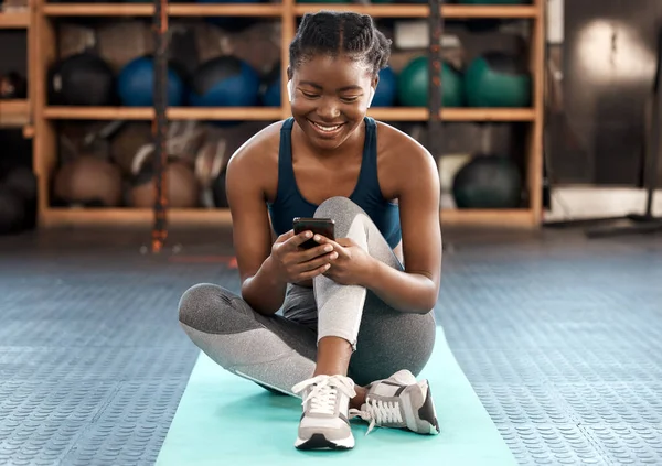 ジムでのソーシャルメディア コミュニケーション ネットワーキングのための幸せな黒人女性 フィットネス 運動後のアフリカの女性や運動選手の入力 テキストメッセージや携帯電話でチャット — ストック写真