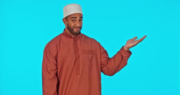 製品の配置や広告のためのモックアップスペースを持つスタジオでの選択 顔やイスラム教徒の男 青色の背景によるマーケティングのためにモックアップ表示されるイスラム男性モデルの決定 オプション 肖像画 — ストック動画