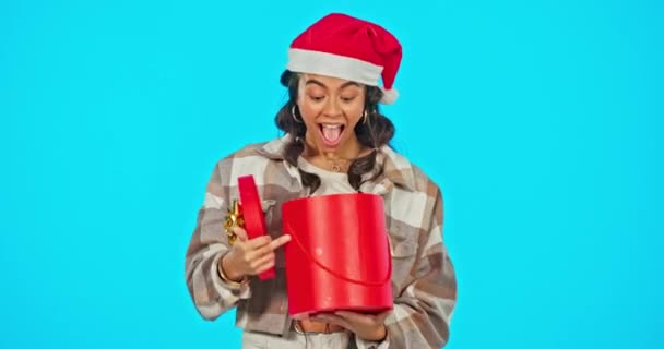 お祝い イベントやパーティーのためのスタジオでプレゼントを持つ幸せ クリスマスや女性 クリスマスプレゼントとサンタの帽子と女性モデルの肖像画青の背景によって隔離 — ストック動画