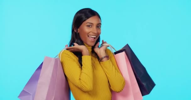 快乐的女人 购物袋 在工作室里眨眼 在蓝色背景下购买 销售或打折 购物或礼品袋装饰华丽的女购物者的画像 — 图库视频影像