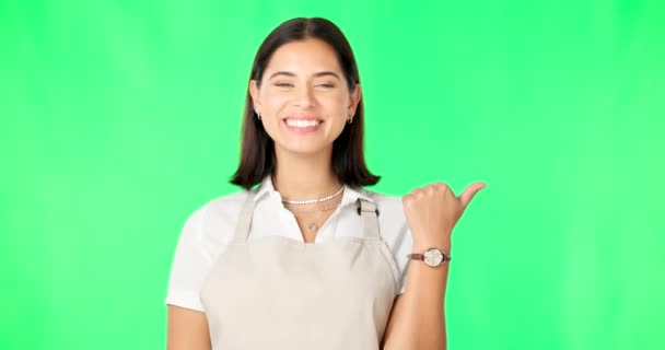 エプロンでモックアップスペースで指を指して緑の画面上の女性 幸せと肖像画 スタジオの背景に広告のウェイトレスやバリスタの選択やプロモーションのための笑顔を持つプロの女性 — ストック動画