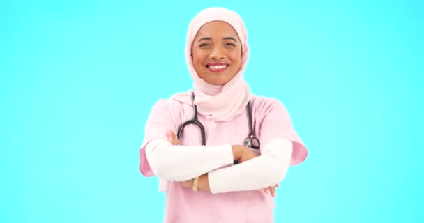 穆斯林妇女 脸上和护士的微笑与胳膊交叉在工作室孤立的蓝色背景模型 来自土耳其的画像 医疗专业人员和自信 快乐和自豪的伊斯兰人士或外科医生 — 图库视频影像