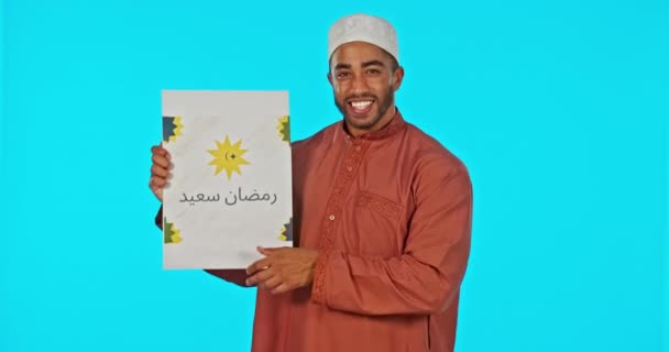 信仰や宗教のためのスタジオで青の背景にラマダーンのムバラク ポスター イスラム教徒の男 彼の文化やアッラーへの信仰を誇りとする幸せな若いイスラム教徒の男性と肖像画 Eidとプラカード — ストック動画