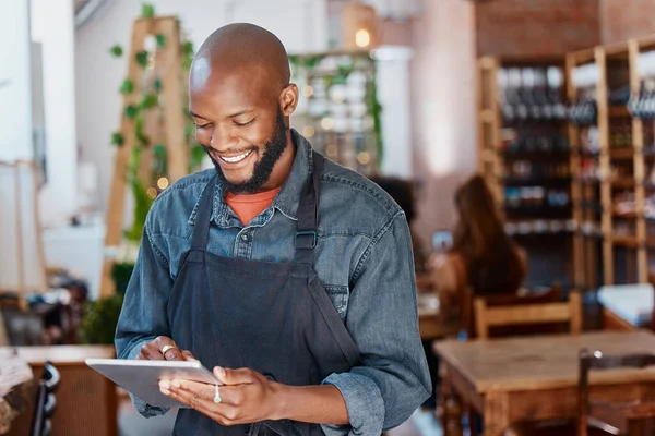 Restaurant, tablet and black man or small business owner, e commerce and online cafe or coffee shop management. Waiter or happy person reading sales on digital technology or internet for his startup.