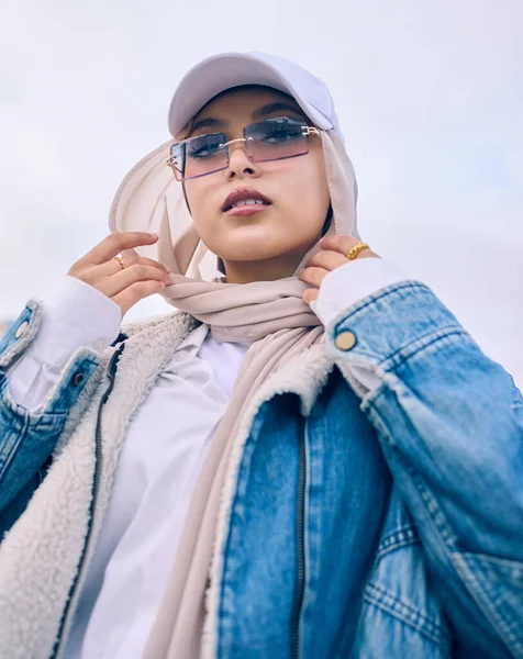 現代的なスタイルのためのキャップ サングラスやスカーフでイスラム教徒の女性の屋外と肖像画 ファッションや低角度 イスラム教 ヒジャーブの流行の若いアラブ人が単独で現代の目撃者にポーズをとる — ストック写真