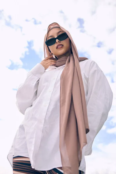时尚和一个穆斯林妇女户外蓝天背景太阳镜和围巾的当代风格 伊斯兰教 信仰和头巾 外面穿着时髦的阿拉伯年轻人 — 图库照片