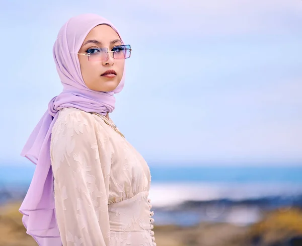 Portrait, fashion or sunglases with a muslim woman on mockup outdoor in a scarf for contemporary style. Islam, faith and hijab with an edgy young arab female person posing outside in modern eyewear.