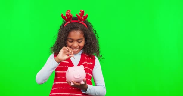 クリスマスの節約 貯金箱と子供は幸福と緑の画面と予算に直面しています 財務学習 笑顔と子供の肖像画とともに隔離されたスタジオの背景とモックアップとコイン現金 — ストック動画