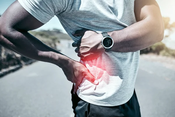 背痛和受伤 一个运动员抱着他疼痛的身体 而在室外锻炼 身体解剖及男性运动员在进行有氧跑步训练时的意外感受 — 图库照片