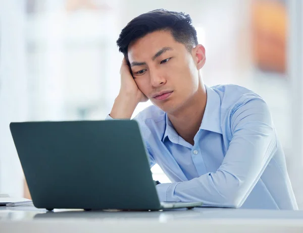 Mental health, businessman tired and worried a with laptop at his desk in a modern workplace office. Fatigue or burnout, problem or mistake and male person sad or stress at his workstation at work.